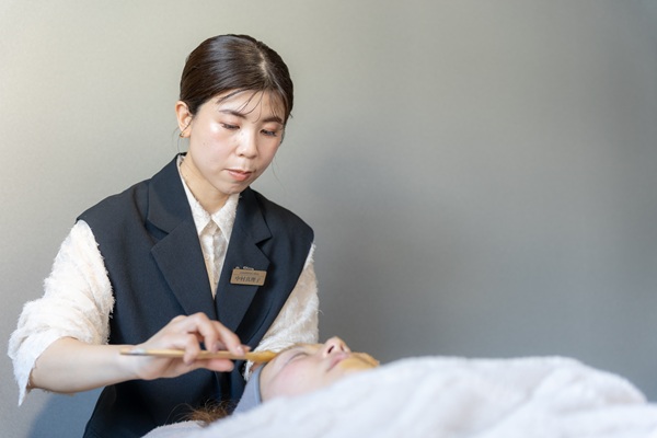 顔の美容施術をするオーナー